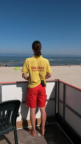 Rettungsschwimmerin auf einem Wachturm am Strand.