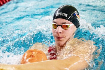 Rettungssportler beim Rückenschwimmen mit Puppe.
