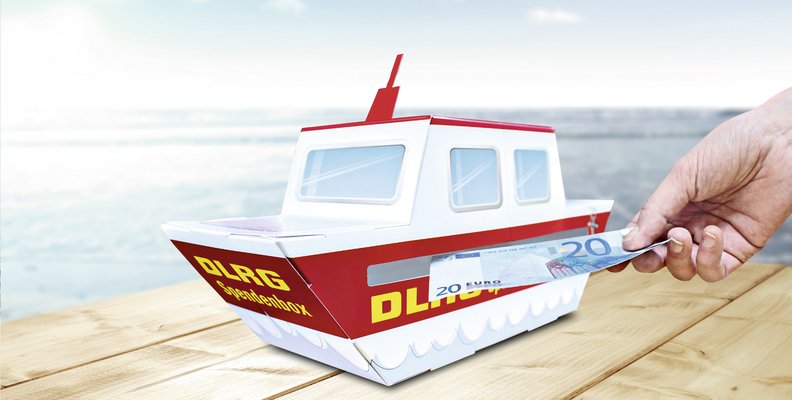 Das Spendenboot der DLRG. Ein Boot aus Pappe, welches einen Innenraum hat. Hiermit können Spenden gesammelt werden.