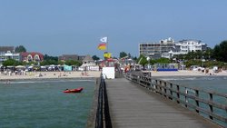 Strand mit Wachturm von einer Seebrücke aus fotografiert.