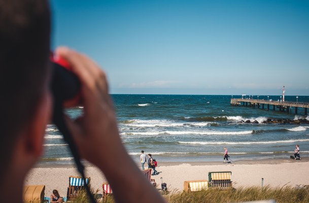 DLRG Rettungsschwimmer schaut durch ein Fernglas auf das Wasser