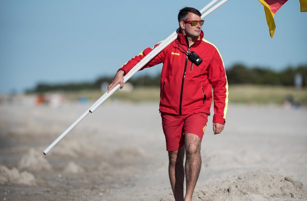 DLRG Rettungsschwimmer mit Flagge für die Badezonen Kennzeichnung