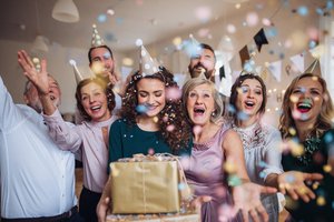 Eine Familie feiert Geburtstag, mit Geschenken und Konfetti
