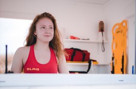 Eine DLRG Rettungsschwimmerin schaut aus dem Fenster der Wachstation