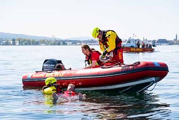 Rettung mehrerer Personen aus dem Wasser von Einsatzkräften mit Boot