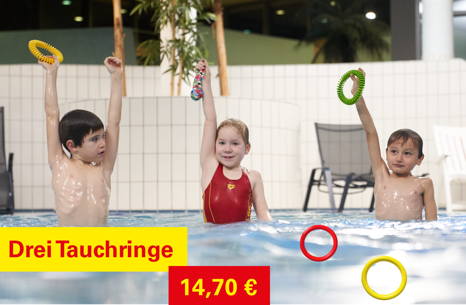 Drei Kinder im Wasser mit Tauchringen in der Hand 