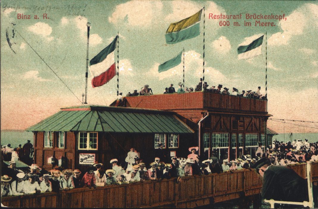 Postkarte mit einer Zeichnung von Menschen, die ankommende Schiffe vom Restaurant am Kopf der Seebrücke in Binz aus beobachten.